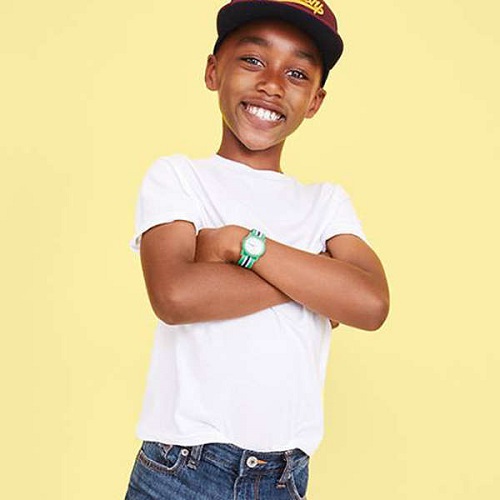 younng boy in white t shirt, hat, and watch, smiling and crossing arms