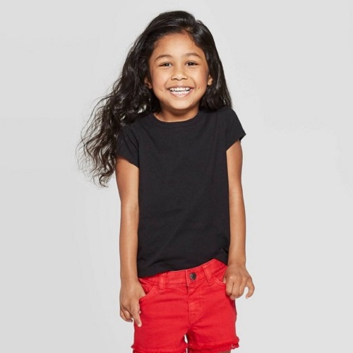 young girl in black t shirt, red shorts, smiling